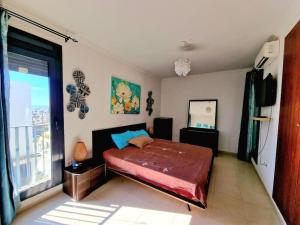 a bedroom with a bed and a large window at F4 résidence hasnaoui in Oran