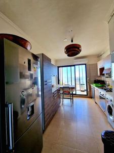 a kitchen with a stainless steel refrigerator and a table at F4 résidence hasnaoui in Oran