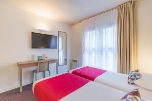 a hotel room with two beds and a desk at Appart'City Classic Lyon Part Dieu Villette in Lyon