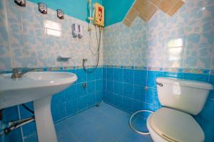 a blue bathroom with a toilet and a sink at Noble Thippanate in Chiang Mai