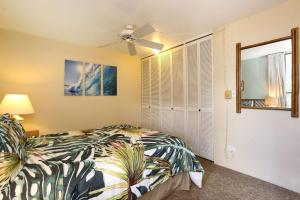1 dormitorio con 1 cama, ventana y ventilador en Paki Maui 313, en Kahana