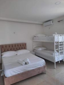 a bedroom with two bunk beds with towels on them at GREEN Apartments in Ksamil