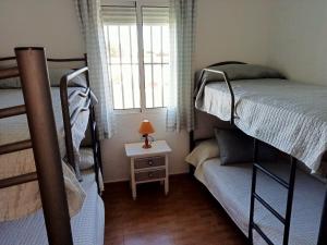 1 dormitorio con 2 literas y ventana en Casa rural El Limonero, en Campano
