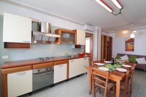 una cucina e una sala da pranzo con tavolo e sala da pranzo di Elegante "casa Karm" 6 posti a Otranto
