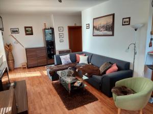 a living room with a blue couch and a table at Apartman Tatry in Tatranská Lomnica