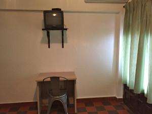 mesa con silla y TV en la pared en Pensión Provenzal, en Mojácar