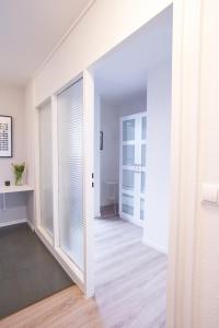 korytarz z białymi ścianami i przesuwanymi szklanymi drzwiami w obiekcie Gemütliches und helles Studio Apartment mit Balkon, Badewanne, WLAN, Parkplatz w Bremie