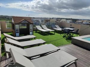 a group of lounge chairs and tables on a roof at Portside Lodge in Marsaskala