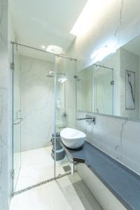 een badkamer met een wastafel en een glazen douche bij Hotel Devgiri in Kolhapur