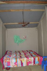 a bedroom with a bed in a room with a ceiling at Bhada Community Homestay 