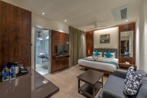 una camera d'albergo con letto e soggiorno di Hotel Devgiri a Kolhapur