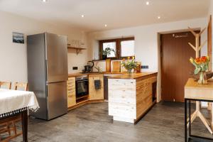 una cucina con frigorifero in acciaio inossidabile e mobili in legno di Fernwohl Kürnbach a Kürnbach