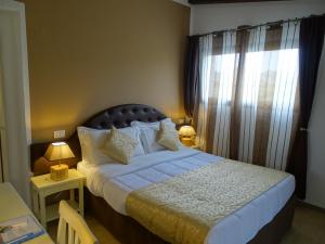 um quarto com uma cama e uma janela com cortinas em Locanda Domus De Vida Turismo Rurale em Palau