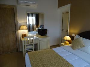 Habitación de hotel con cama y escritorio con TV. en Locanda Domus De Vida Turismo Rurale, en Palau