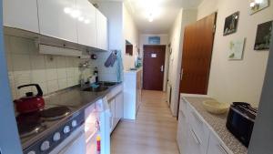 a kitchen with a sink and a stove top oven at DANIELA Seeblick Appartement Haus Hänsel Gretel am Ossiacher See, Hallenbad, Skiarena Gerlitzen in Stiegl +25 photos
