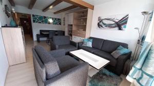 a living room with a couch and chairs and a table at DANIELA Seeblick Appartement Haus Hänsel Gretel am Ossiacher See, Hallenbad, Skiarena Gerlitzen in Stiegl