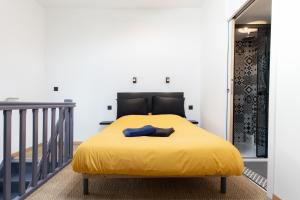 AU COEUR DES VIGNES ENTRE BEAUNE ET DIJON في Montceau-et-Écharnant: سرير اصفر في غرفة بها درج