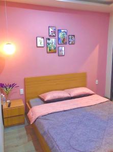 a bedroom with a pink wall with a bed at Amy Hotel in Can Tho