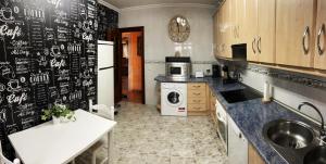 uma cozinha com uma parede de quadro com uma máquina de lavar e secar roupa em casa rural valderaduey 
