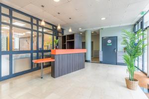 an office lobby with a counter and a plant at Appart'City Classic Lyon Vaise St Cyr in Lyon