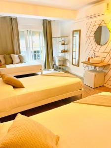 Habitación de hotel con 2 camas y espejo en La Bartola Guesthouse, en Ibiza