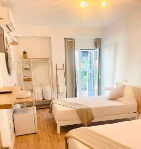 a hotel room with two beds and a window at La Bartola Guesthouse in Ibiza Town