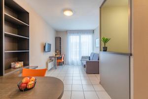 a kitchen and living room with a table and a couch at Appart'City Classic Lyon Vaise St Cyr in Lyon