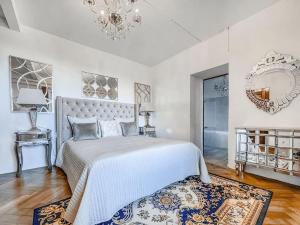 ein weißes Schlafzimmer mit einem großen Bett und einem Kronleuchter in der Unterkunft Brilliant apartment in Château du Châtelard in Montreux