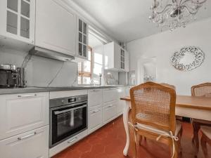 a kitchen with white cabinets and a table and a chair at Brilliant apartment in Château du Châtelard in Montreux