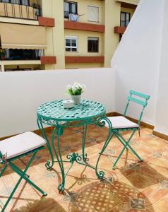La Bartola Guesthouse في مدينة إيبيزا: طاولة وكرسيين وطاولة عليها ورد