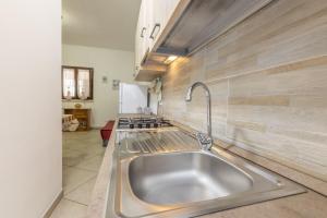 a kitchen with a stainless steel sink and a stove at Giulio’s Apartment in Taviano