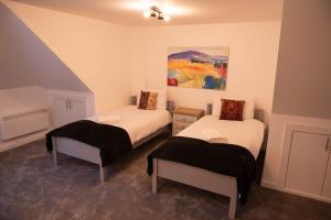 Habitación con 2 camas y una pintura en la pared. en Walnut Flats-F4, 2-Bedroom with Ensuite - Parking, Netflix, WIFI - Close to Oxford, Bicester & Blenheim Palace, en Kidlington