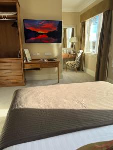 a bedroom with a bed and a tv on the wall at St Kyrans Guest House in Virginia