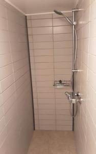 a shower in a bathroom with a tiled wall at Mettes Romanti in Hadsund