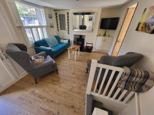 sala de estar con sofá azul y sillas en The seaside retreat en Kent