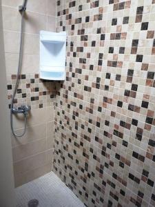 a bathroom with a shower with a soap dispenser on the wall at Habitación matrimonial privada con areas compartidas in Las Lagunas