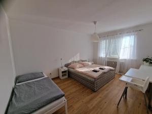 a bedroom with a bed and a desk and a table at Apartment Šimon II. in Františkovy Lázně