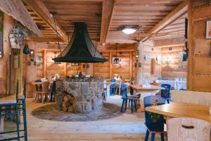 restauracja z kamiennym kominkiem w pokoju z drewnianymi ścianami w obiekcie Domki Javorina w Zakopanem