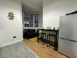 een woonkamer met een tafel en een koelkast bij Bee Accommodations in Leicester