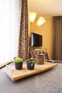 a hotel room with a table with two plants on it at Landhaus Riedl in Bad Füssing