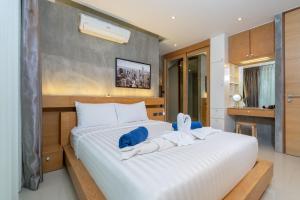 Un dormitorio con una gran cama blanca con toallas. en Villa Natural Touch A3, en Kamala Beach 31 fotos más