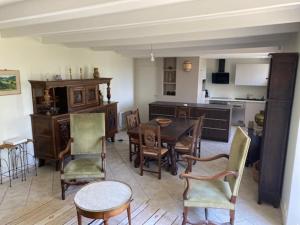 cocina y comedor con mesa y sillas en Maison vue mer et accès plage à pied, en Clohars-Carnoët