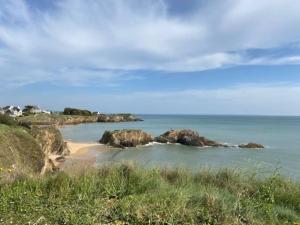 vistas a una playa con rocas en el agua en Maison vue mer et accès plage à pied, en Clohars-Carnoët