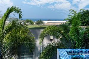 Una vista desde el balcón de un resort con palmeras. en Villa Natural Touch A3, en Kamala Beach