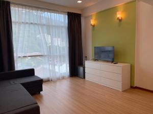 a living room with a couch and a television on a dresser at Deview Hotel Penang in Ayer Itam