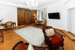 a living room with a couch and chairs and a television at Medieval apartment Juliette in Montreux