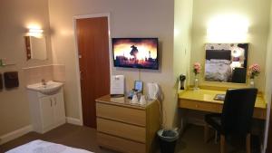 a hotel room with a desk and a sink and a bathroom at Moorland House in York