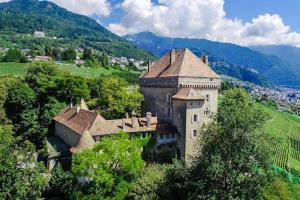 an old building on a hill with mountains in the background at Medieval apartment Juliette in Montreux