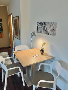 a dining room with a wooden table and white chairs at gemütliche Wohnung alpenländisch in Lüdenscheid