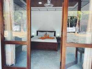 a bedroom with a bed with a orange bow on it at Sea Sand Resort in Kalpitiya